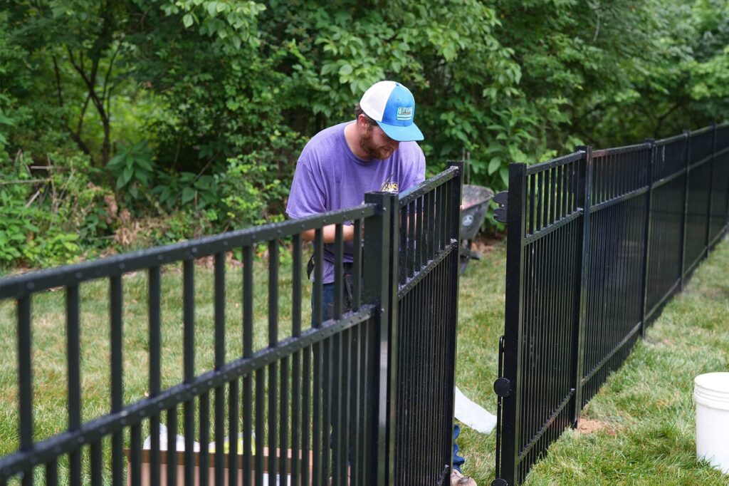 Eads fence employee installing a new aluminum fence.