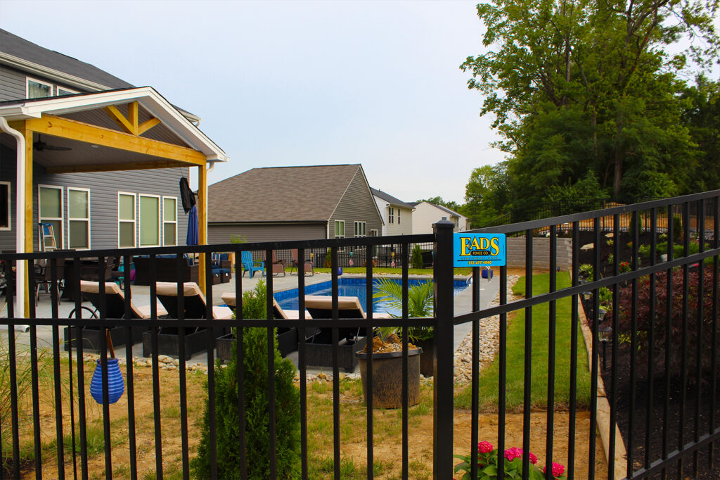 The backyard of a house that has a pool and is fenced in