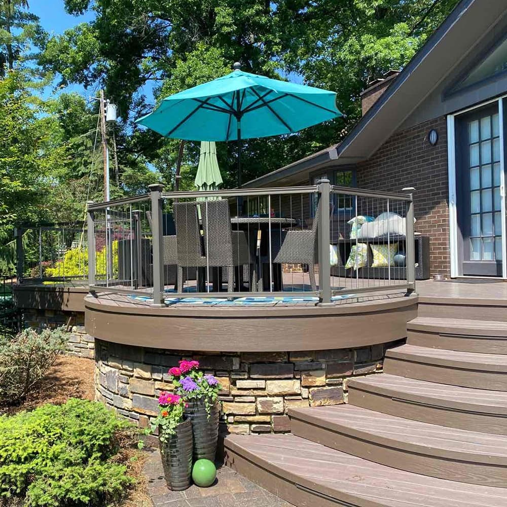 A custom circle cutout of a brown deck with stones supporting it