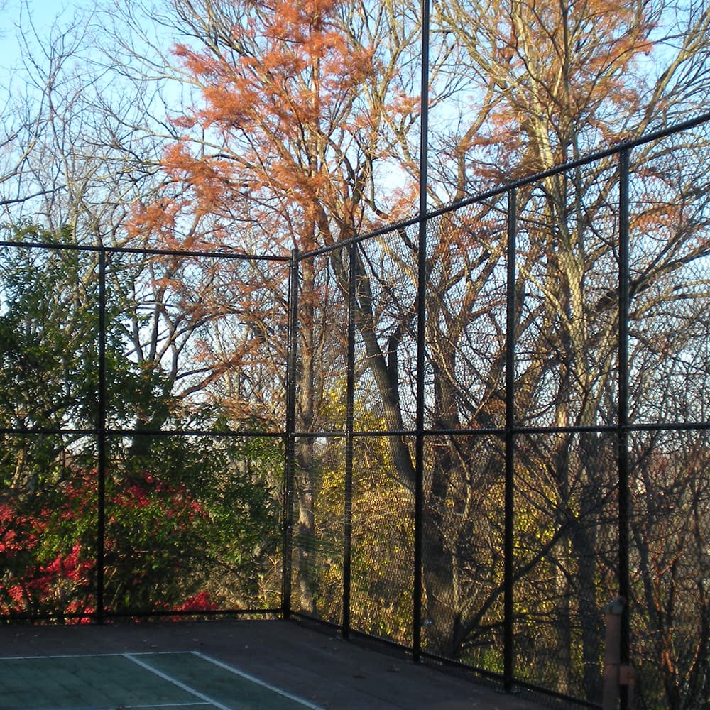 A high black chain linked fence around a tennis court