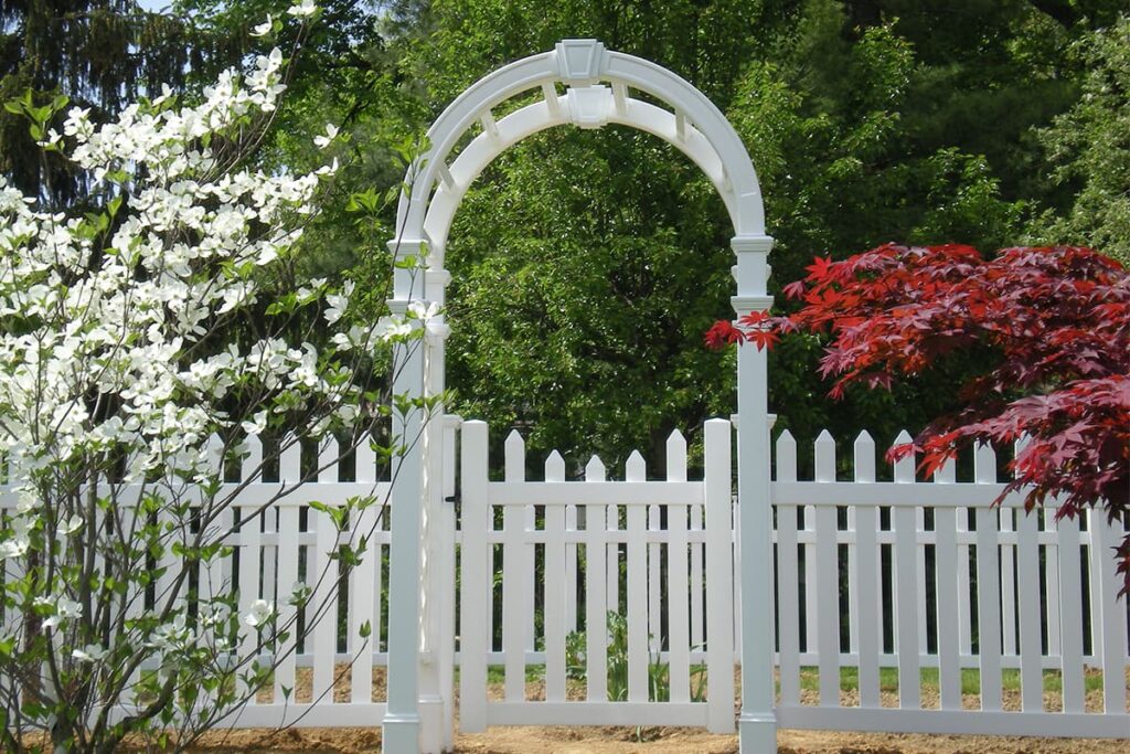 A white vinyl fence with an arbor