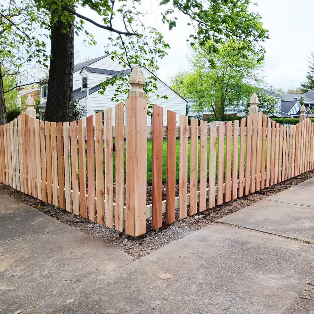 The corner of a wood fence that is decorative