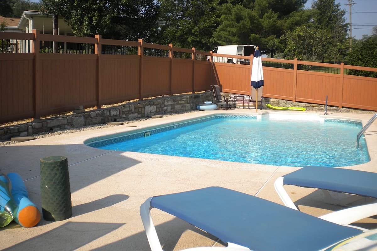 A brown vinyl fence around a pool